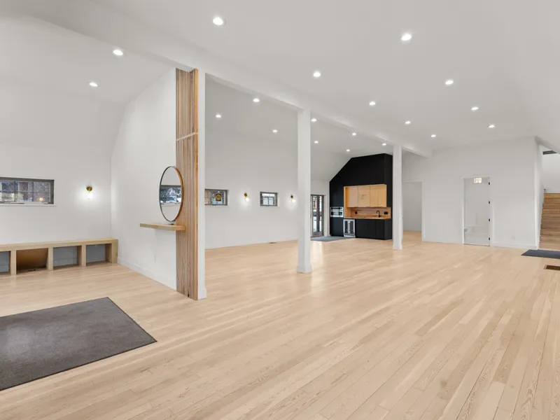 Vaulted great room with a wood slat accent column and open sightline to the kitchen and stairs