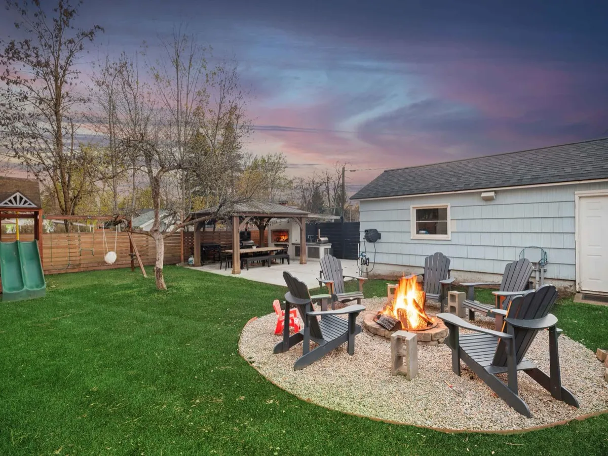 Backyard fire pit and timber pergola structure at twilight