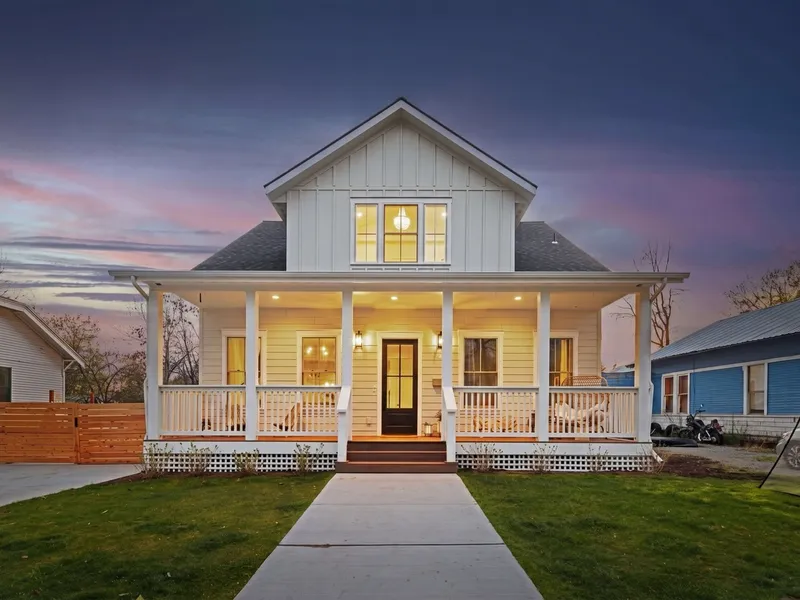 Front view of the craftsman home at dusk with warmly lit windows and porch