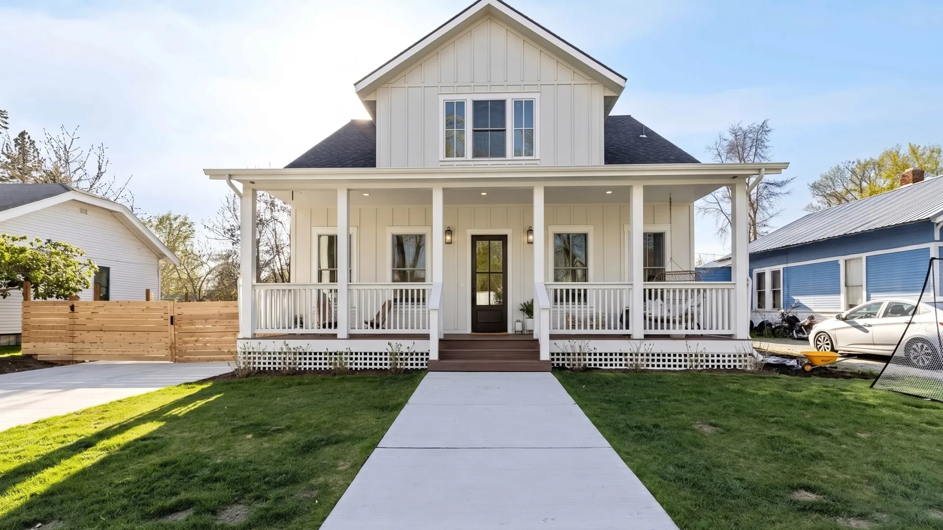White farmhouse-style craftsman home with a wraparound porch on a spring lawn in Coeur d'Alene's Garden District