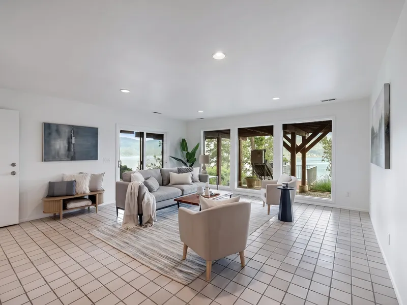 Family room with tile flooring and a timber-frame covered deck overlooking the lake