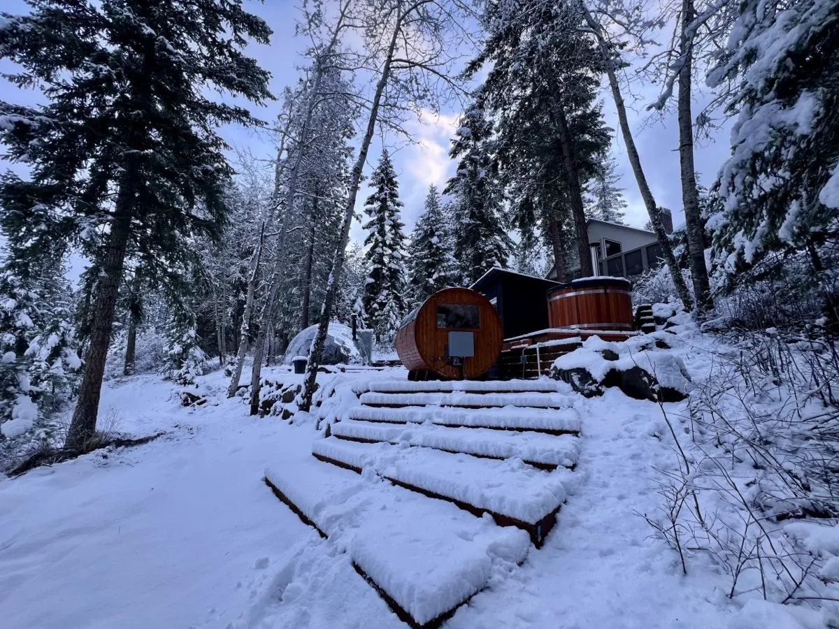 Cedar sauna and cold-plunge tub on a snow-covered patio