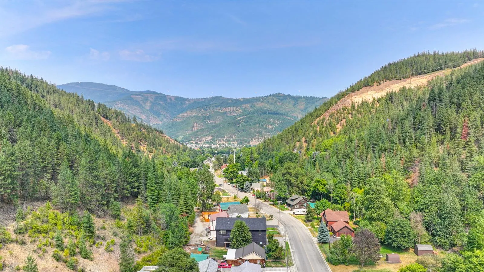 Aerial view of a custom home in the Silver Valley, forested mountains beyond