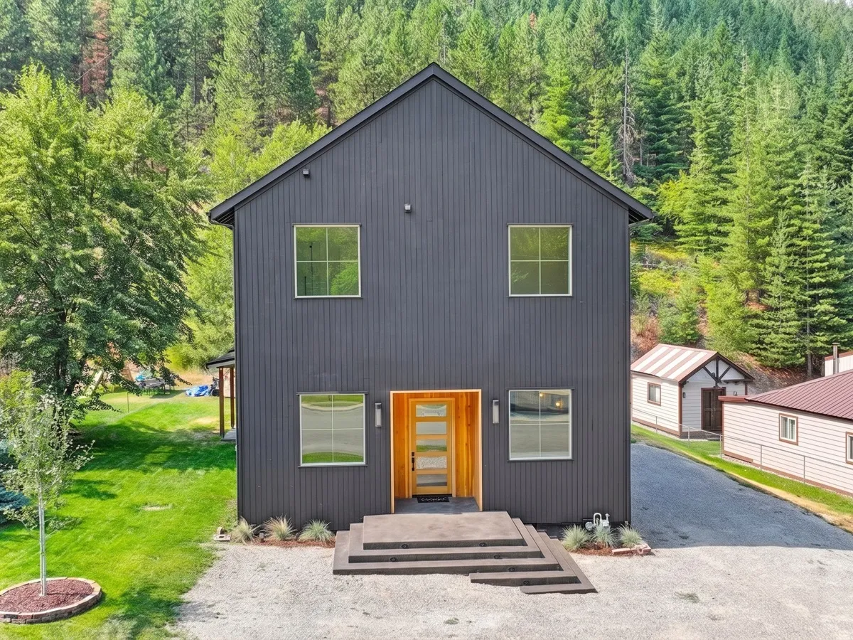 Black board-and-batten custom home exterior with a cedar entry