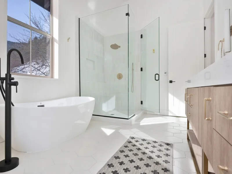 Primary bathroom with a freestanding soaking tub, black fixtures, and a glass walk-in shower